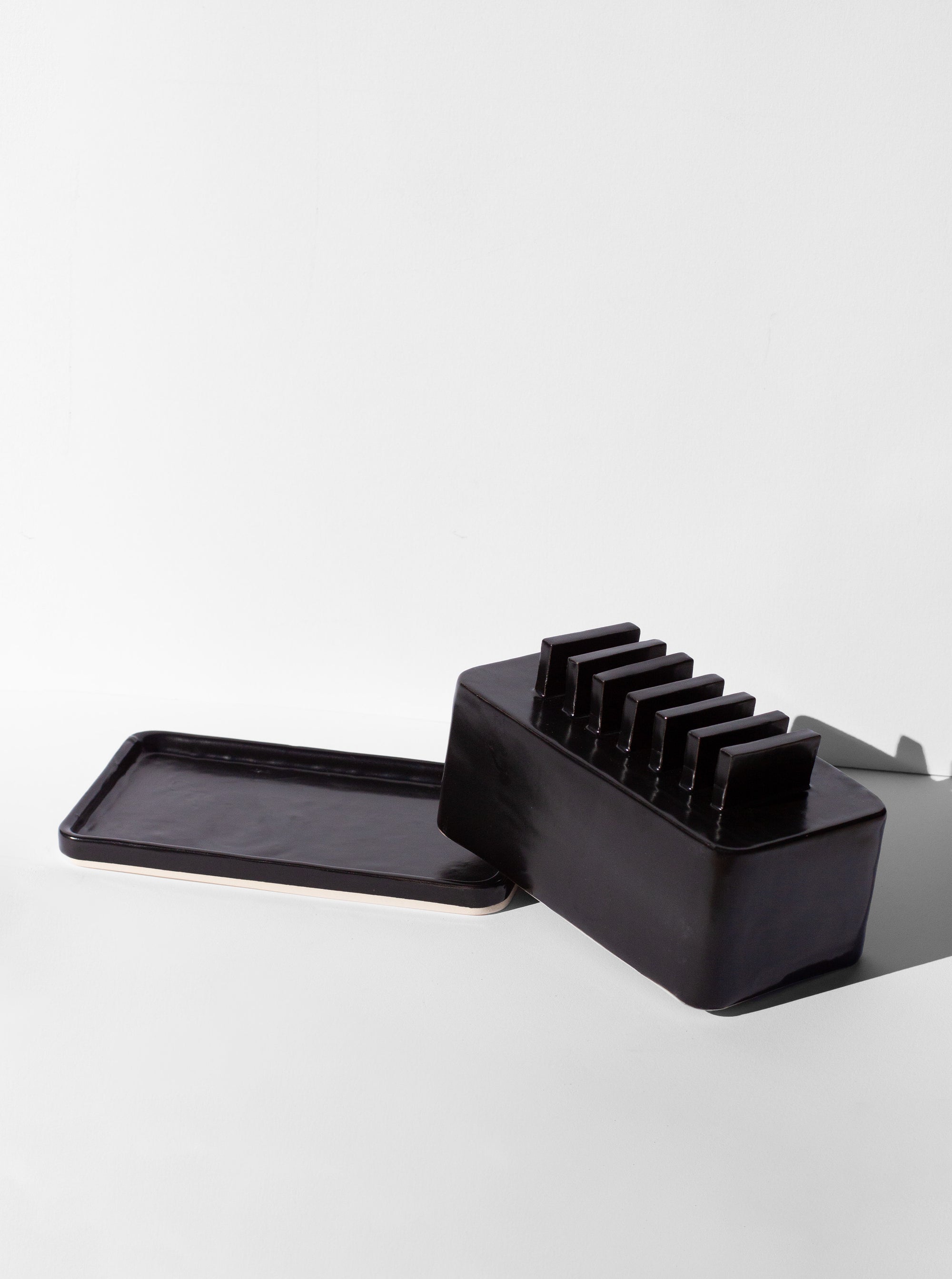 Handmade Black butter dish with repeated geometric flange design on the lid