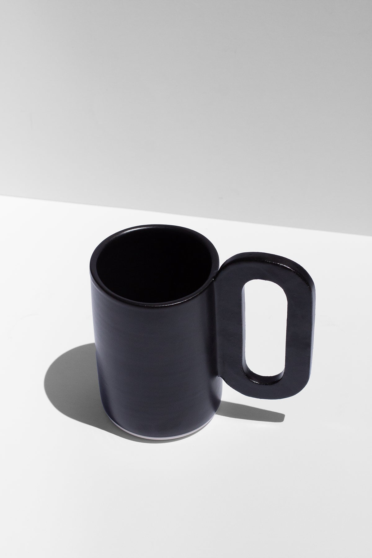 Handmade Tall black mug with loop shaped handle