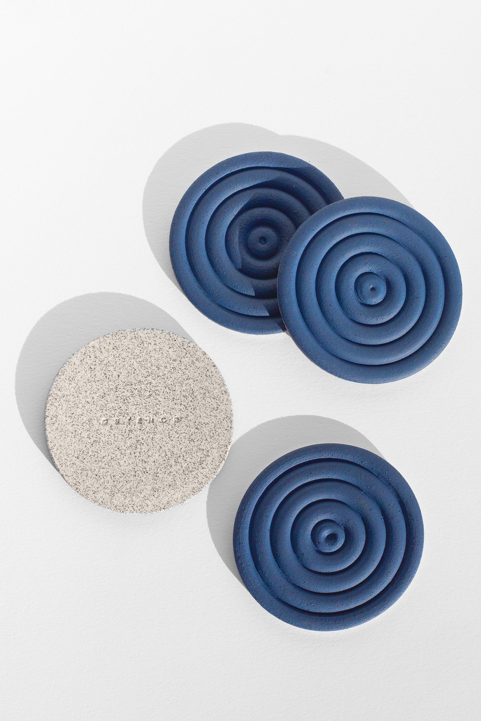A Handmade set of four cobalt blue drink coasters with concentric circle design and speckled finish