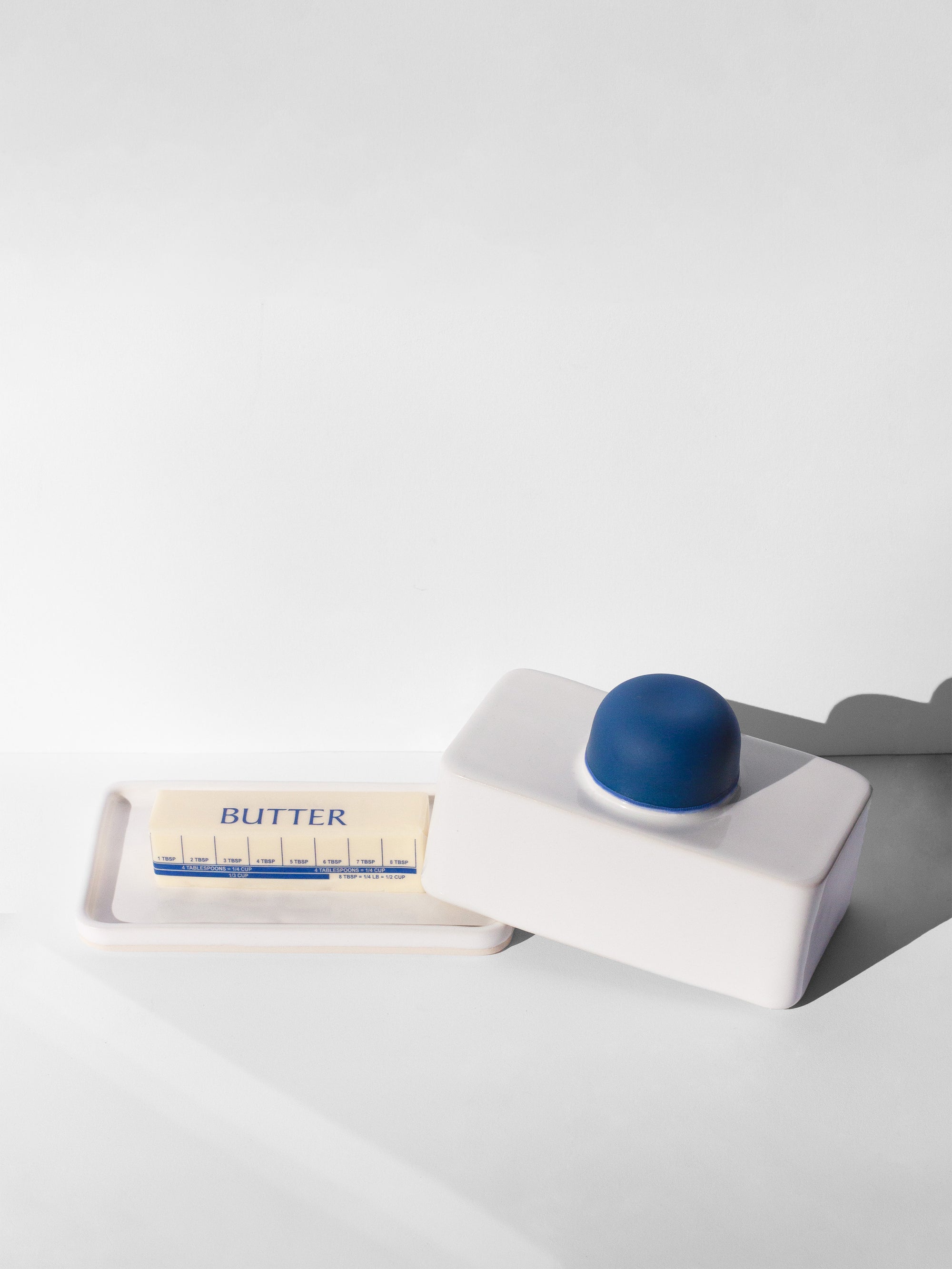 Handmade white and cobalt blue butter dish with cobalt blue knob handle.
