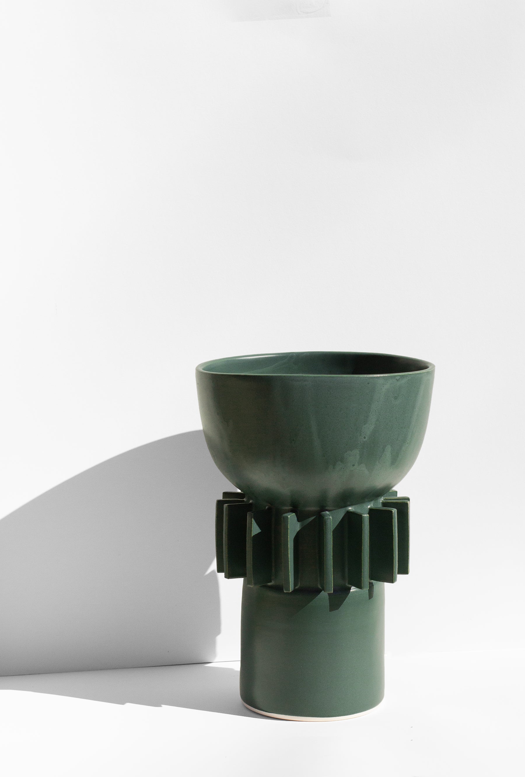 Handmade Tall green vase with rounded top and flange design around the outside.