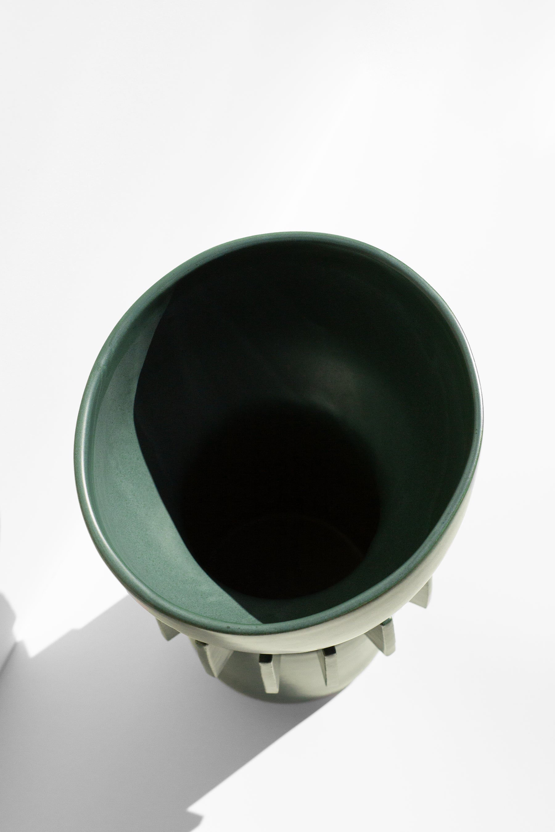 Handmade Tall green vase with rounded top and flange design around the outside.