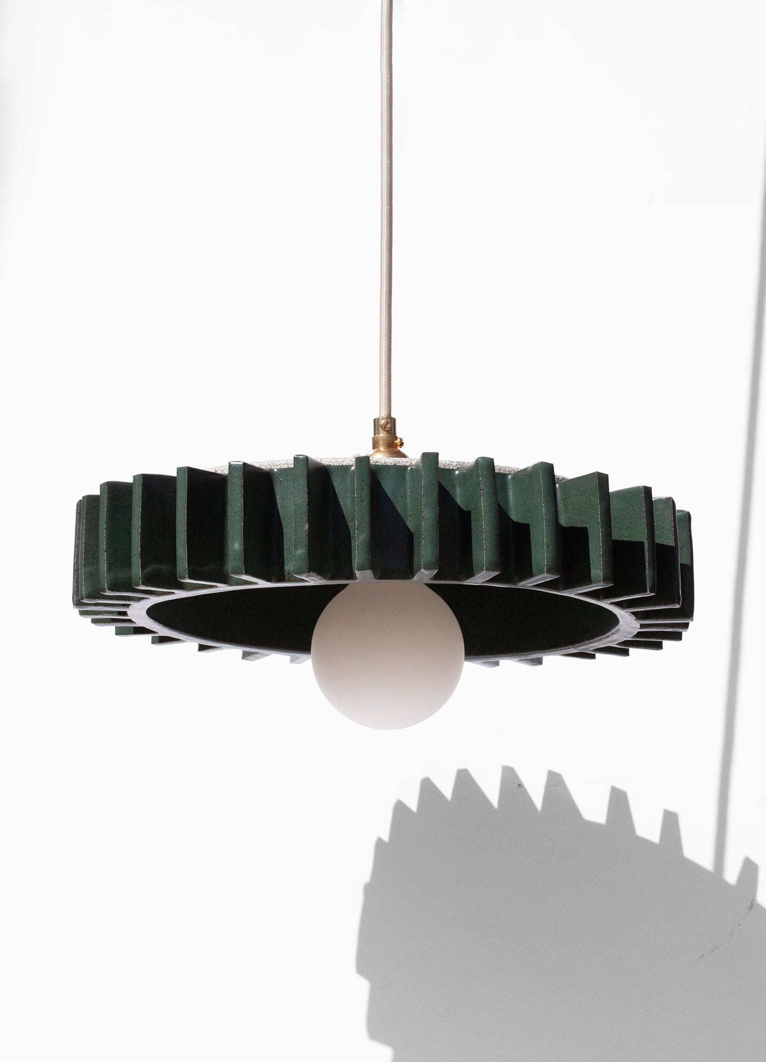 Handmade Green pendant light fixture with geometric flange design on outside edge