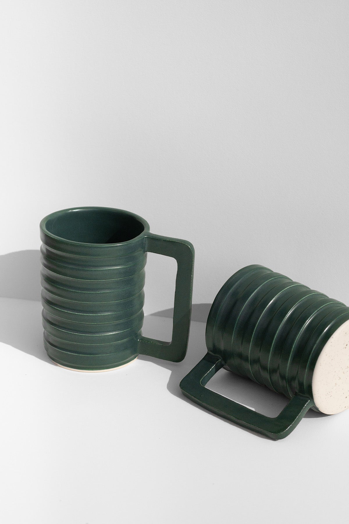 Handmade Green mug with carved ridged on the outside and a geometric handle