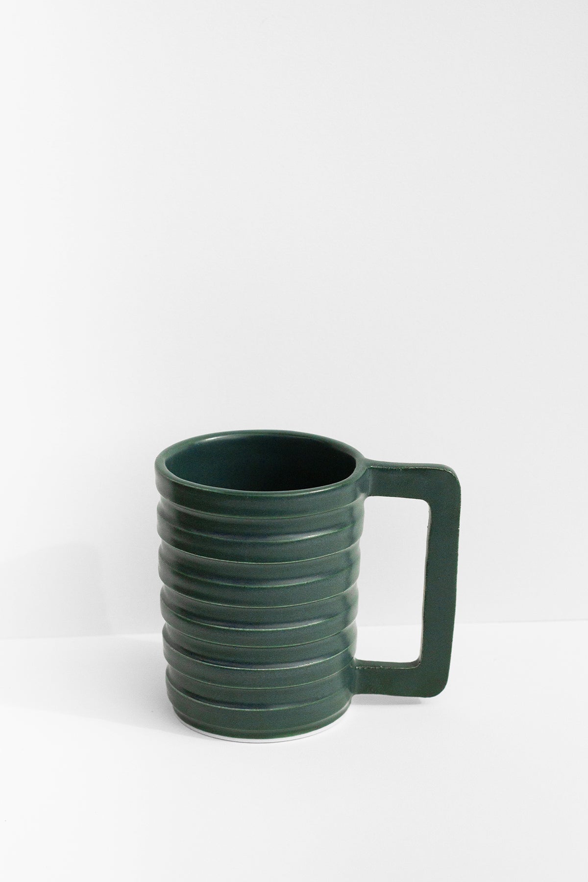 Handmade Green mug with carved ridged on the outside and a geometric handle