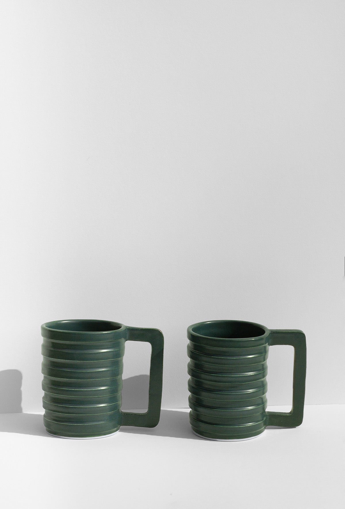 Handmade Green mug with carved ridged on the outside and a geometric handle