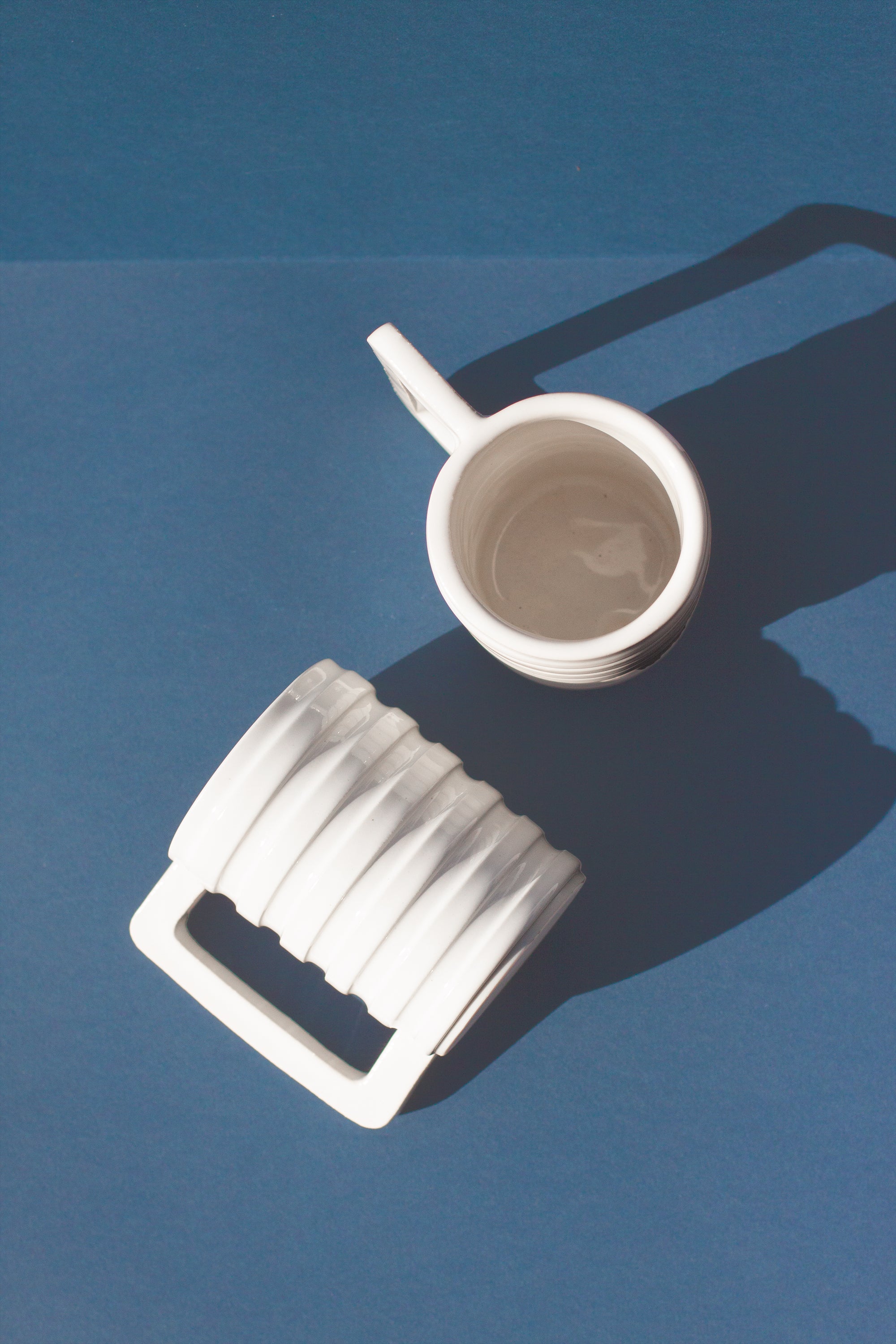 Handmade White mug with carved ridges on the outside and a geometric handle