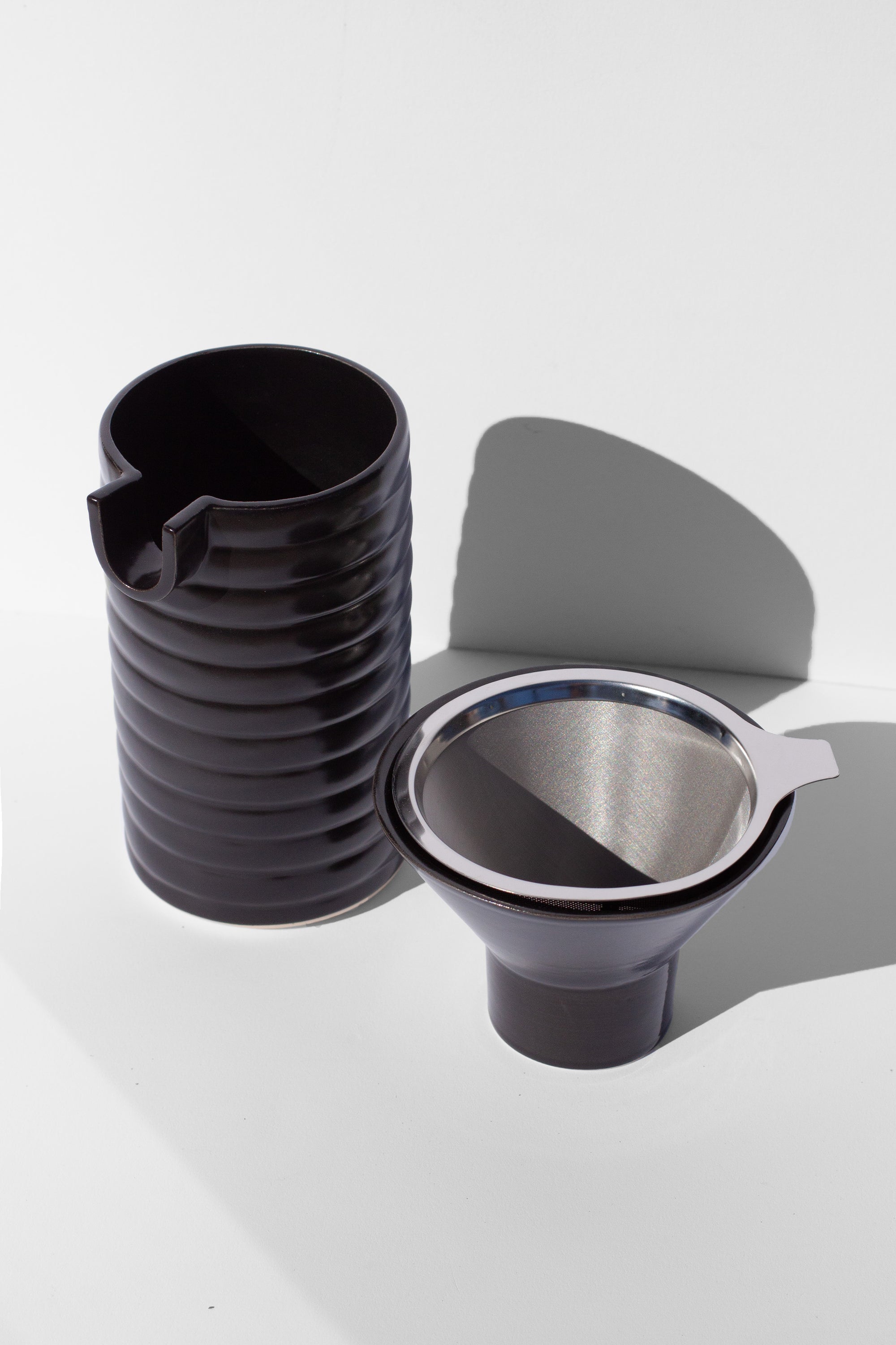 Handmade Black ceramic coffee pour over with wavy surface decoration. 