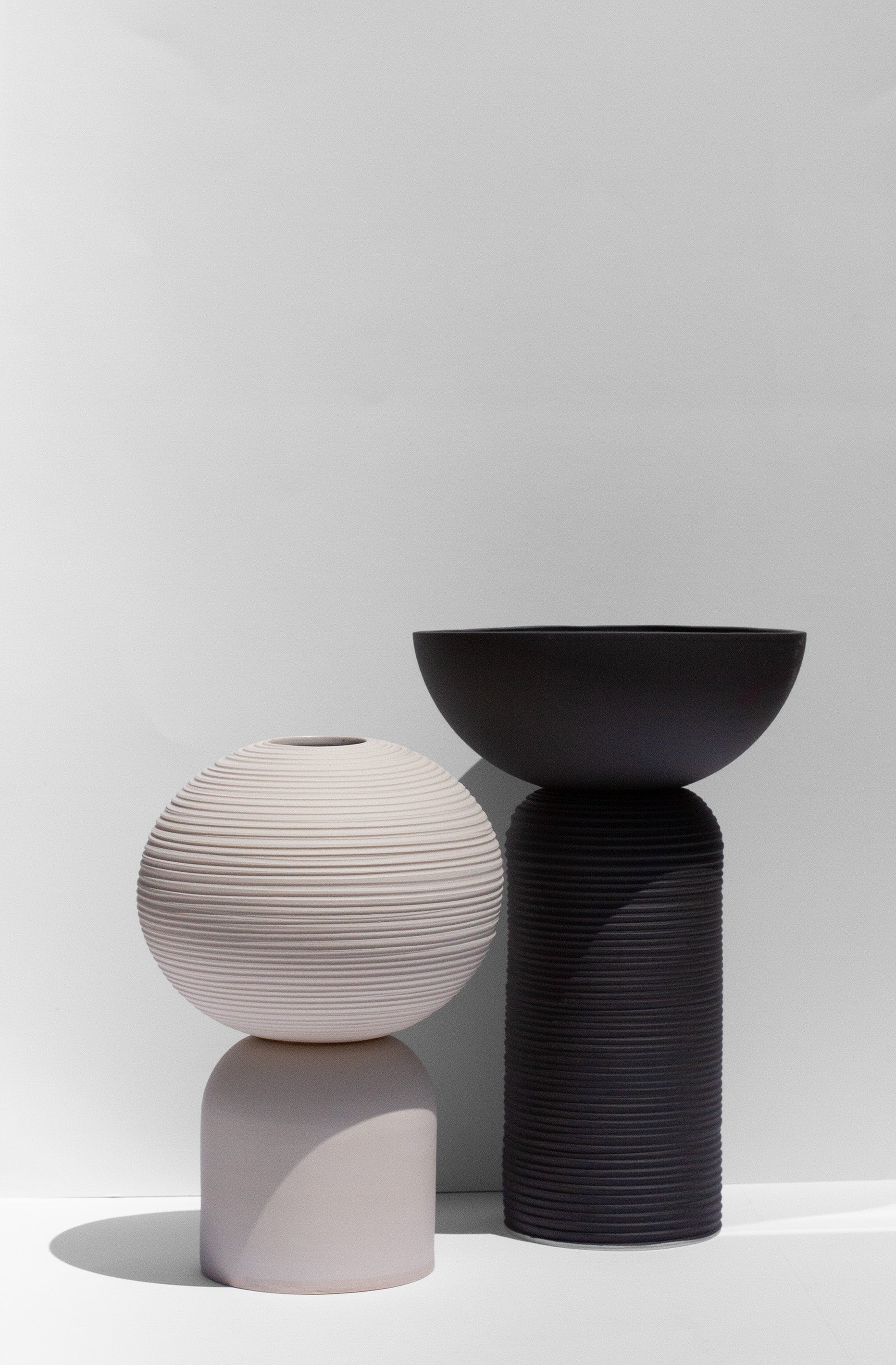 Handmade Rounded white vase with pedestal base and carved ridge texture.
